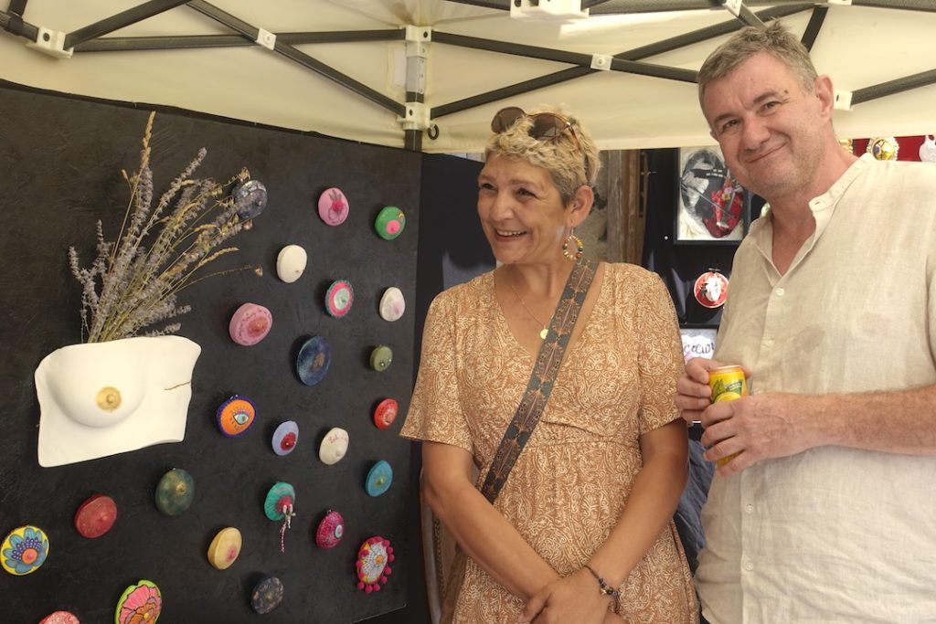"Lydie et ChrisBodyCast devant le Mur de l’Amant Téton, installation artistique de moulages corporels après cancer du sein, exposition au Salon d’Art Brut de Meysse 2025"